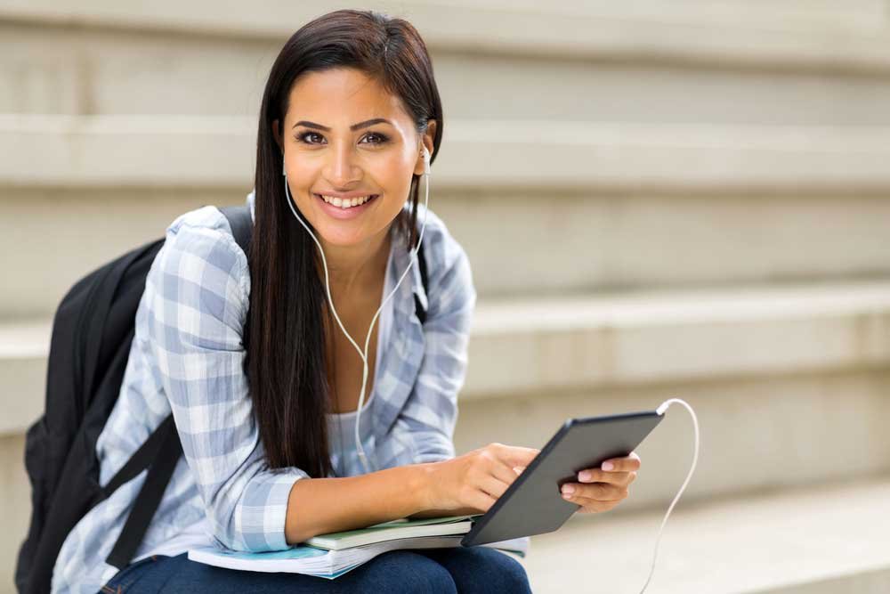 international student with laptop smiling