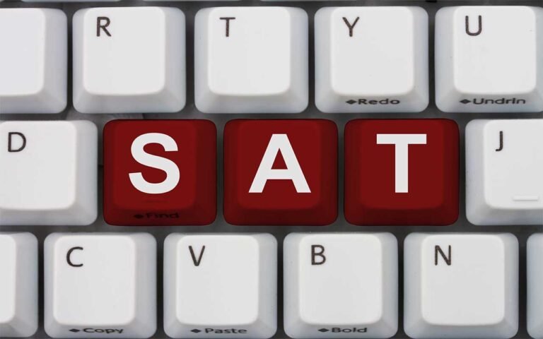 digital SAT pronoun antecedent agreement with sat written in purple on a gray keyboard